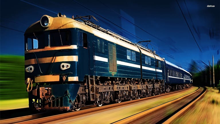 A powerful electric locomotive painted in deep blue with distinctive orange and white horizontal stripes speeds through a scenic countryside landscape. The